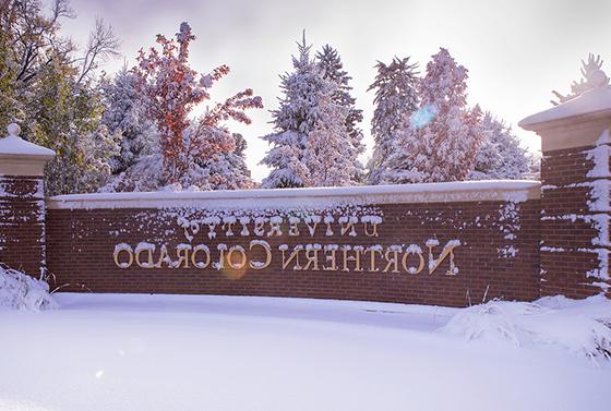 University of 北ern Colorado brick sign covered in a dusting of snow.